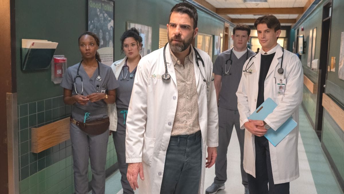 Zachary Quinto as Dr. Oliver Wolf stands in a hospital hallway with his team in a scene from the Brilliant Minds Season 2 premiere. (Photo Credit: Courtesy of NBC.)